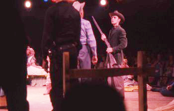 Neal Arsenal (Claggett), with rifle, confronts Jean Shepherd (Destry).