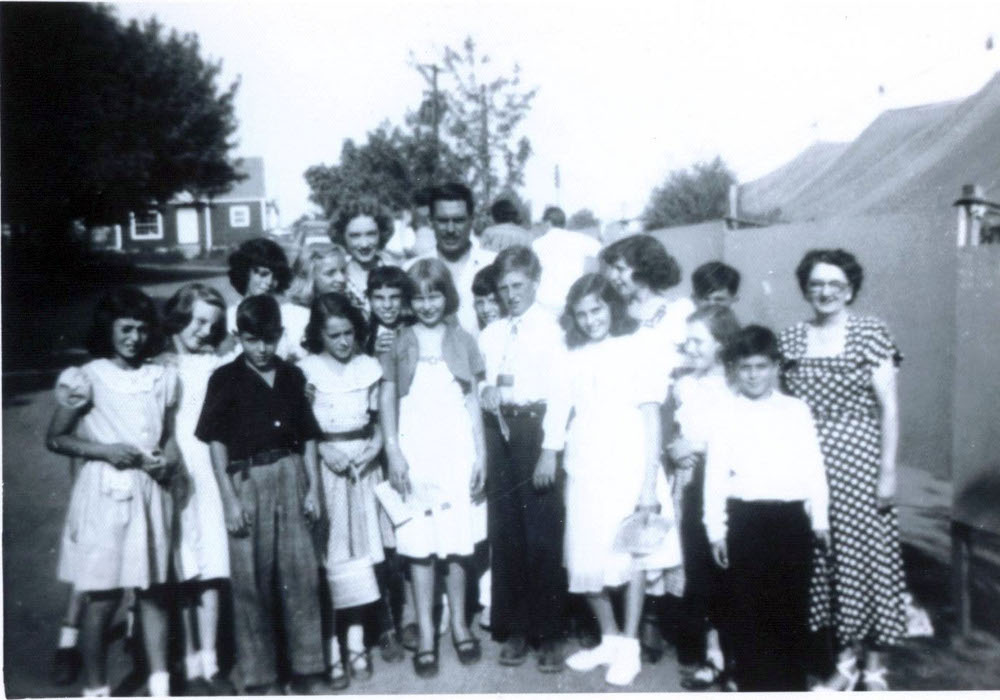 1949 photo of Montessori children posing in front of Susan Foster and Wilbur Evans outside the Music Circus tent to the right.